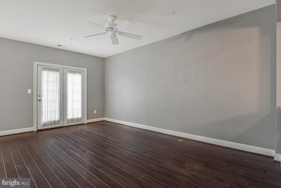 8045 Gatehouse Road, Unit 17 Falls Church, VA 22042 - Photo 7 of 32 a view of an empty room with wooden floor and a window