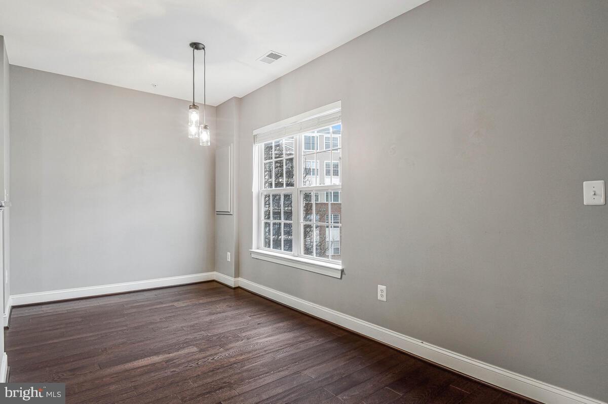 8045 Gatehouse Road, Unit 17 Falls Church, VA 22042 - Photo 9 of 32 a view of an empty room with wooden floor and a window