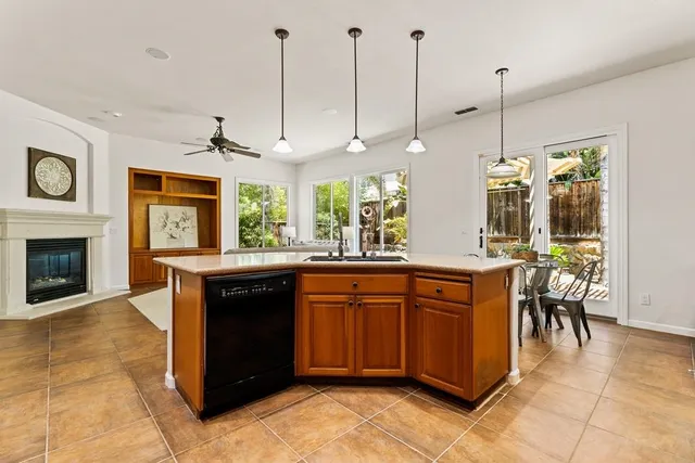 a kitchen with stainless steel appliances granite countertop a stove a sink and a wooden floor