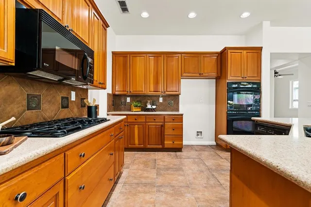 a kitchen with stainless steel appliances granite countertop a stove a sink and a refrigerator