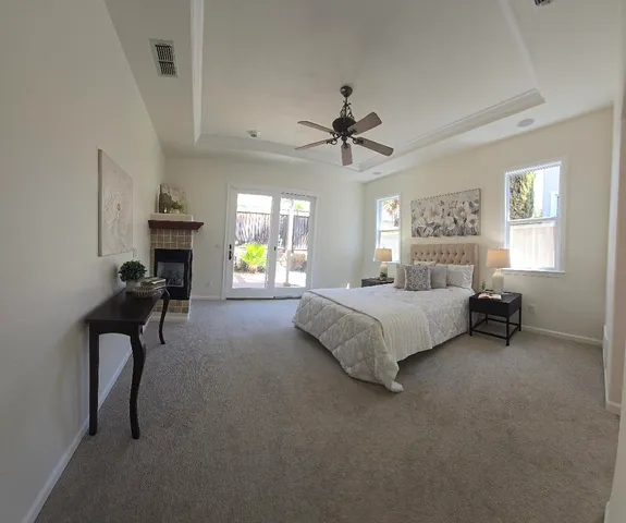 a spacious bedroom with a bed a chandelier and a couch