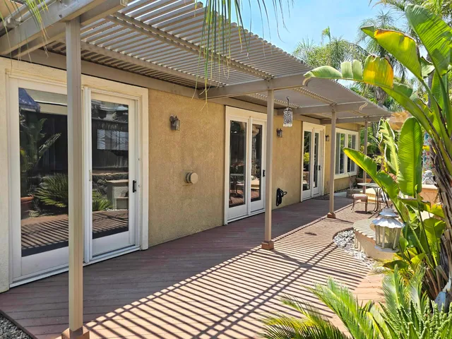a view of a patio with table and chairs under an umbrella