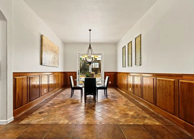 a dining room with furniture a chandelier and wooden floor