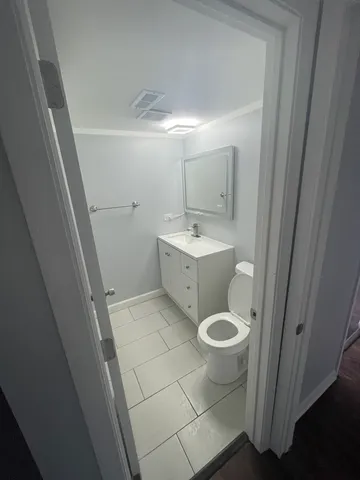 a bathroom with a toilet a sink a mirror a bathtub and vanity