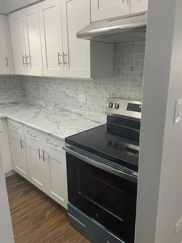 a stove top oven sitting inside of a kitchen