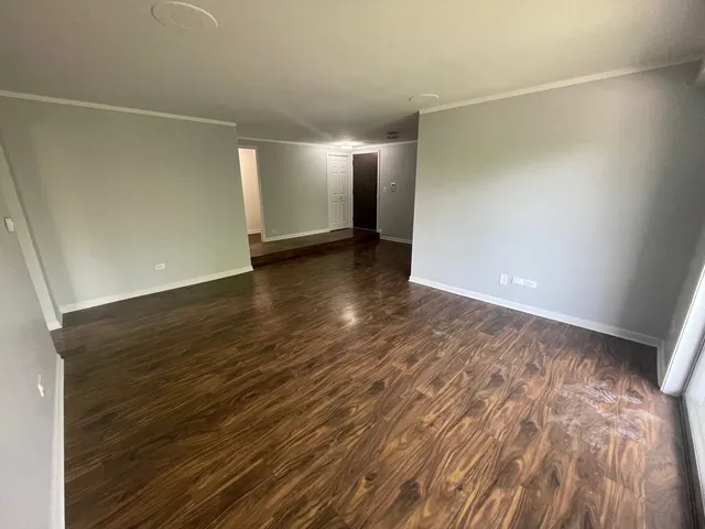 a view of an empty room with wooden floor