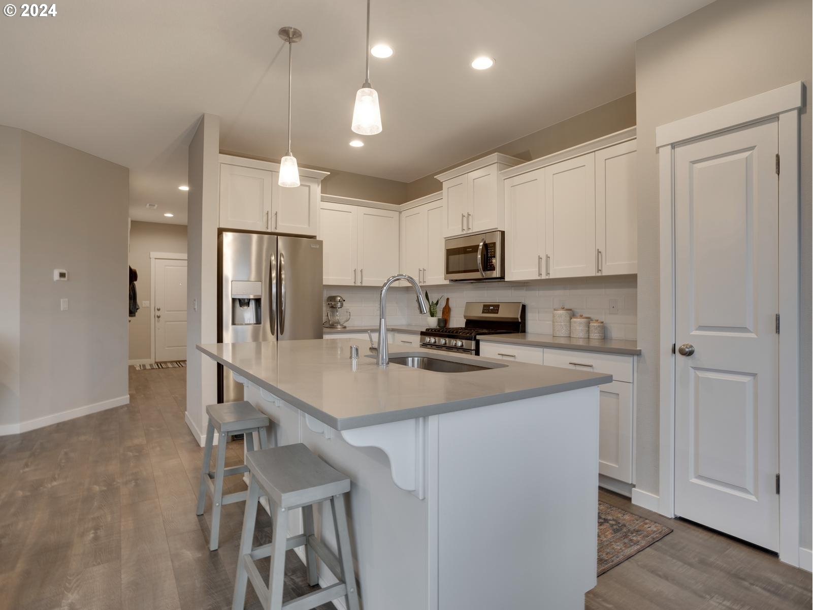 8708 North 3rd Way Ridgefield, WA 98642 - Photo 7 of 30 a kitchen with stainless steel appliances a refrigerator stove microwave and cabinets