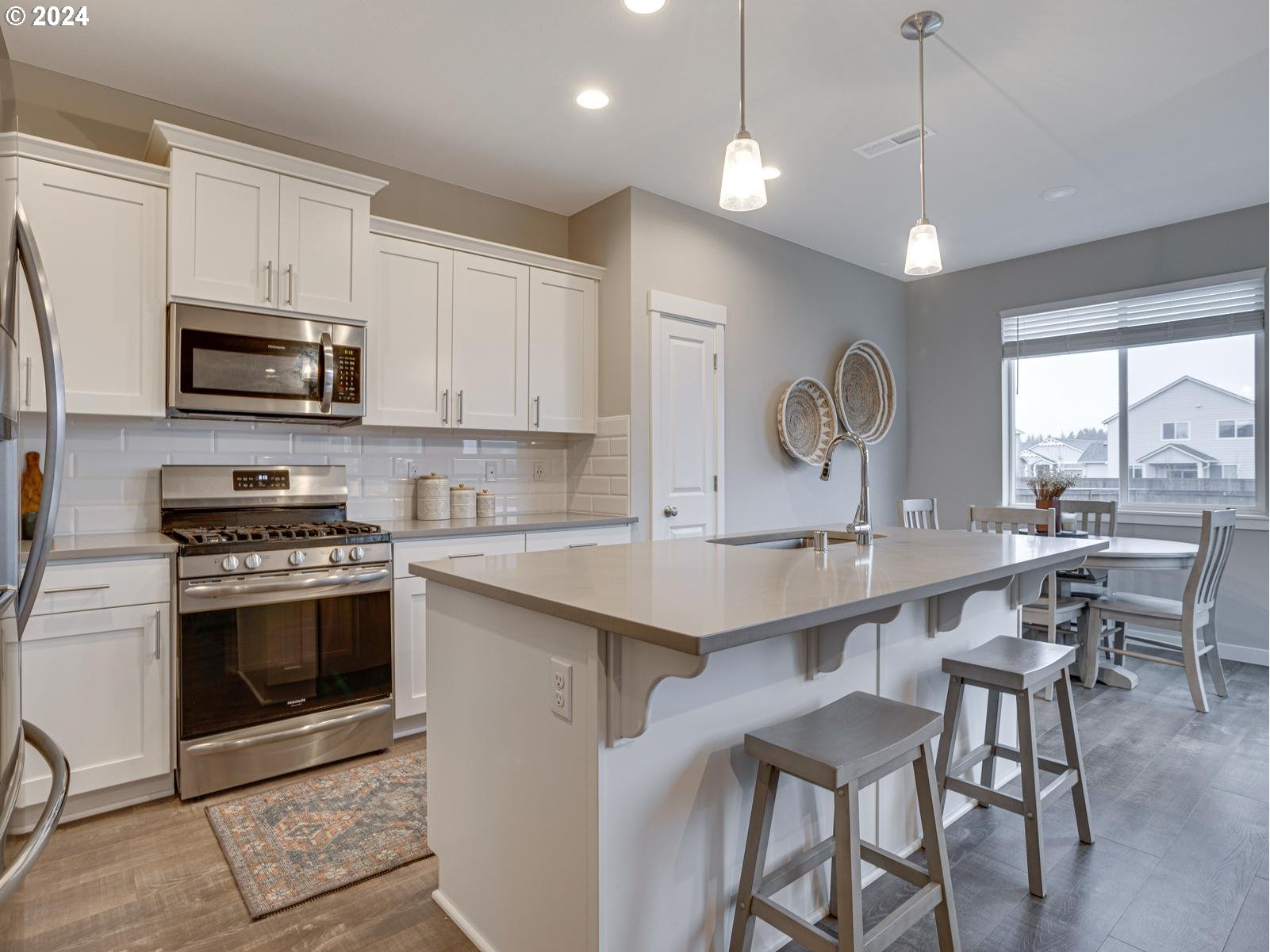 8708 North 3rd Way Ridgefield, WA 98642 - Photo 8 of 30 a kitchen with stainless steel appliances a stove a sink a microwave a dining table and chairs