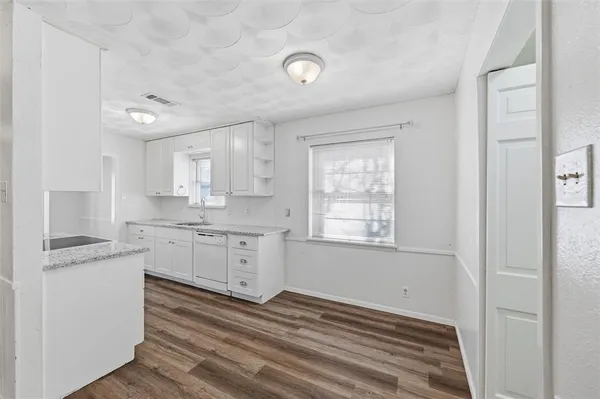 a kitchen with granite countertop white cabinets and white appliances