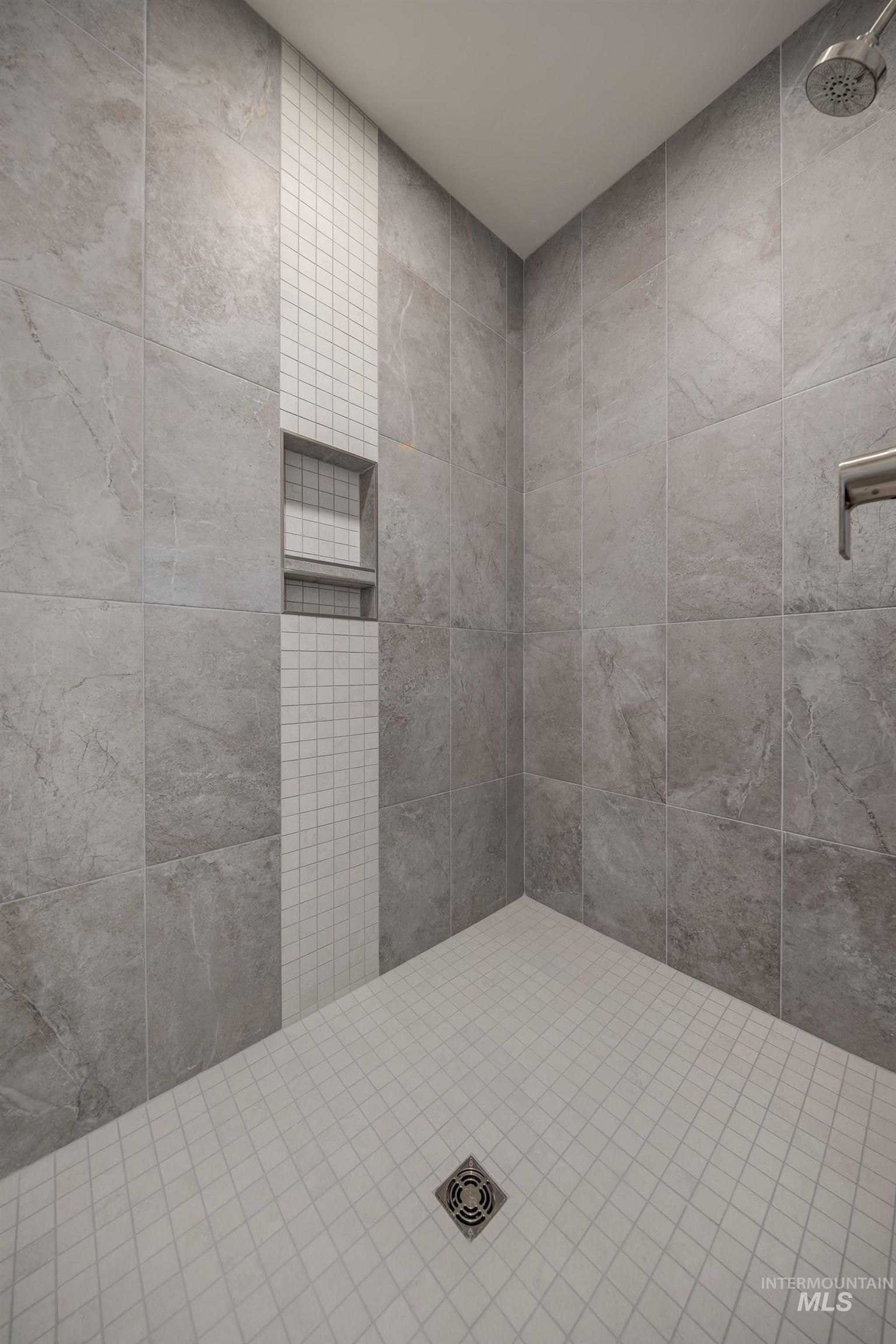 1371 Hansen Road Weiser, ID 83672 - Photo 22 of 44 Tiled shower with large format wall tiles, a mosaic tile accent strip, an integrated shower niche, and a tiled shower floor