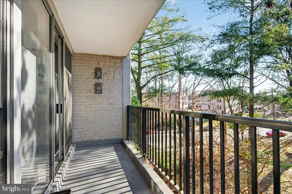 a living room with stainless steel appliances furniture and a kitchen view