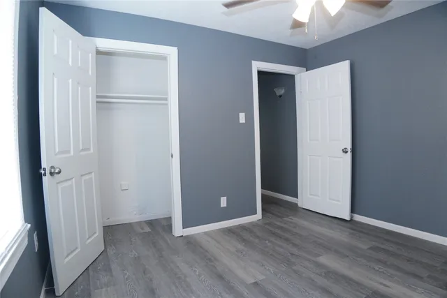 an empty room with closet and a chandelier fan