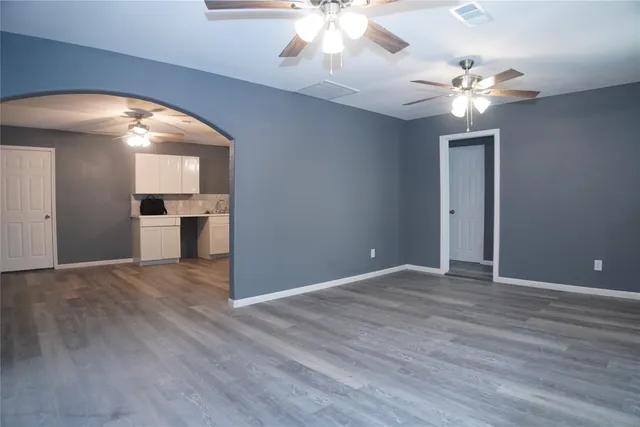 a view of an empty room with a chandelier fan