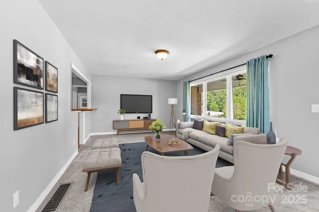a living room with furniture a flat screen tv and a large window