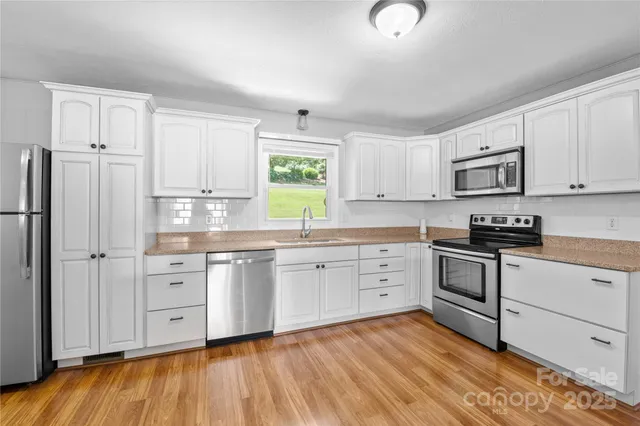 a kitchen with granite countertop white cabinets and white appliances