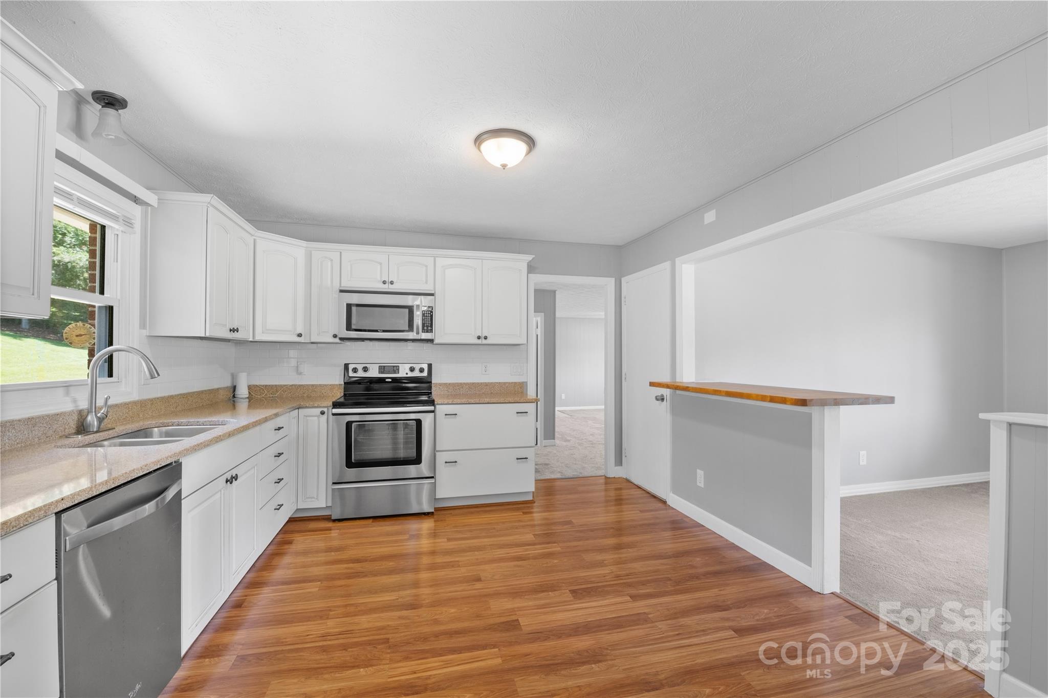 111 Curtis Creek Road Candler, NC 28715 - Photo 9 of 28 a kitchen with granite countertop a refrigerator and a stove top oven