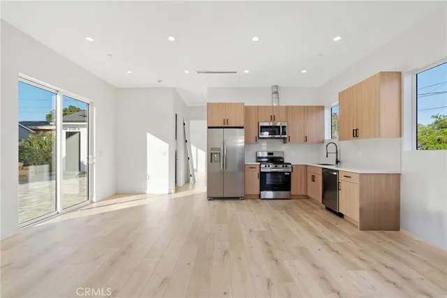 a kitchen with stainless steel appliances a refrigerator sink and cabinets