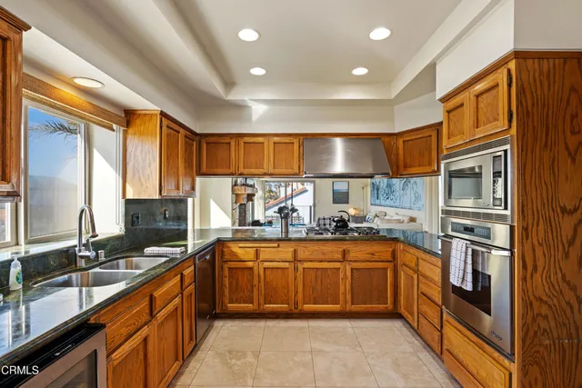 a kitchen with stainless steel appliances a sink stove and cabinets