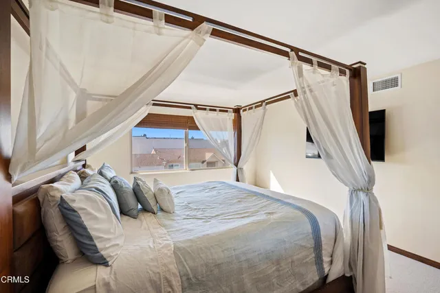 a bed sitting in a bedroom next to a window