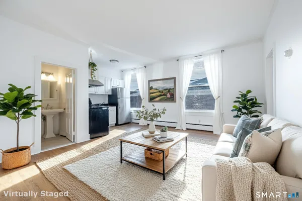 a living room with furniture potted plant and kitchen