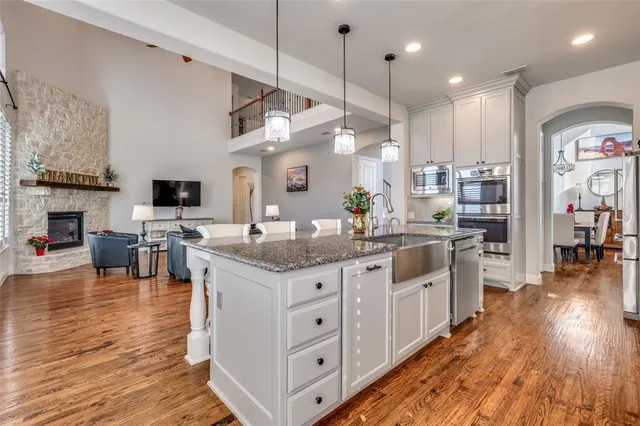 a kitchen with stainless steel appliances granite countertop a stove and a wooden floors
