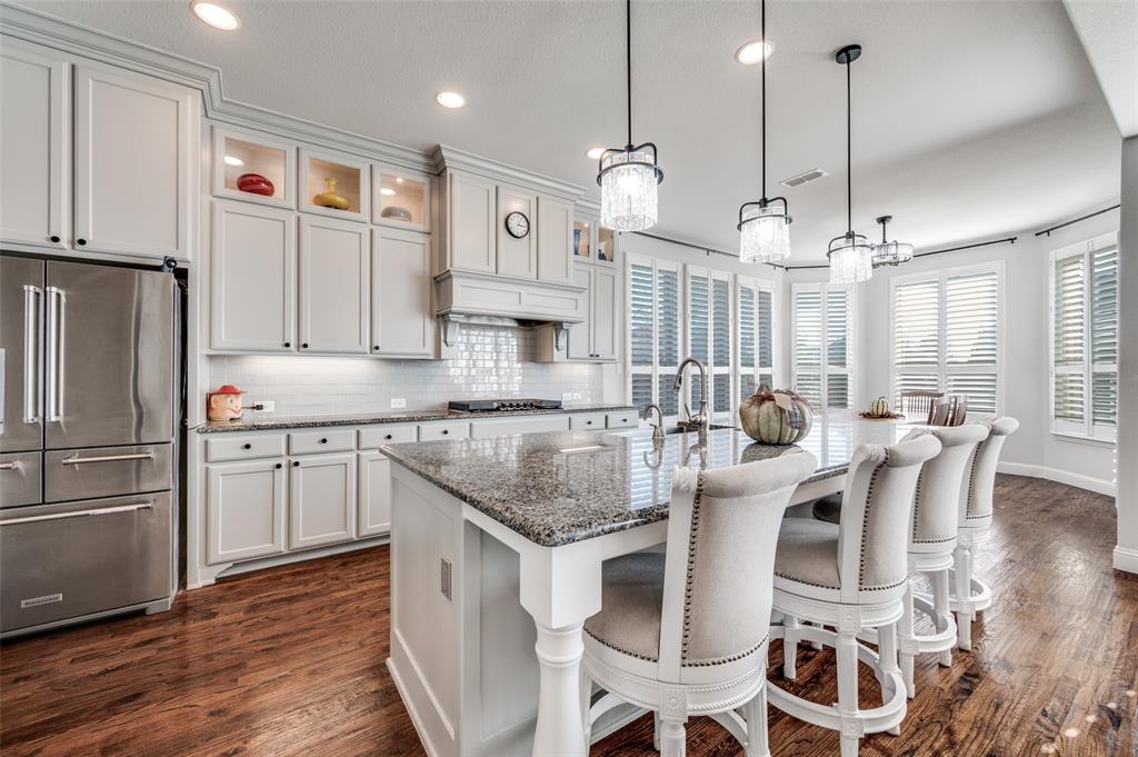 2631 Seabiscuit Road Celina, TX 75009 - Photo 15 of 40 a kitchen with stainless steel appliances granite countertop a sink a stove a refrigerator and island with wooden floor