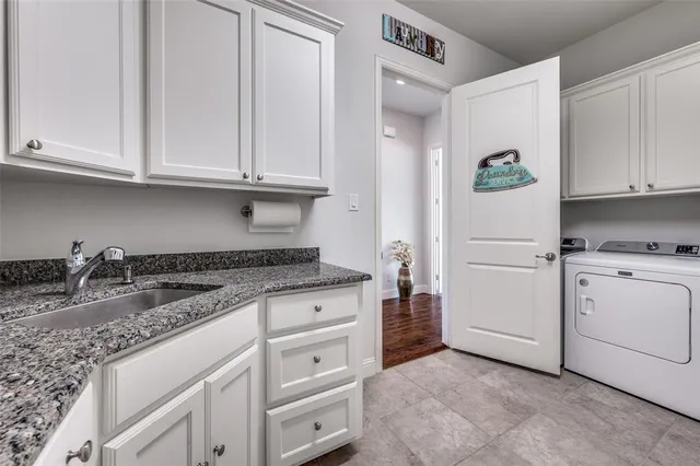 a kitchen with granite countertop white cabinets and white appliances