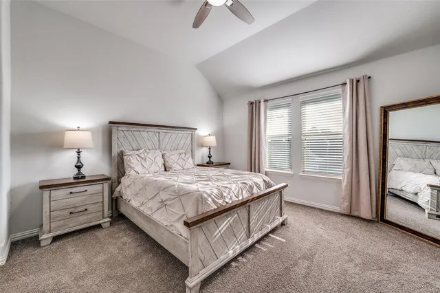 a bedroom with a bed lamp and a large window