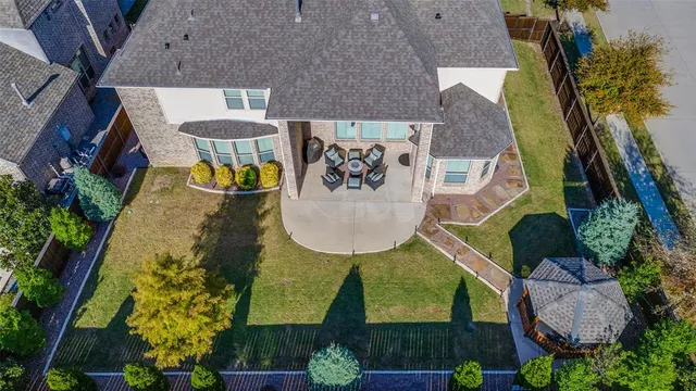 an aerial view of a house with swimming pool and large trees