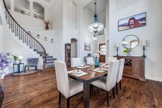 a view of a dining room with furniture a chandelier and wooden floor