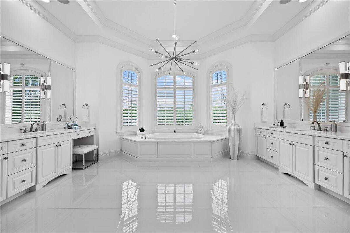 5775 Lady Luck Road Palm Beach Gardens, FL 33418 - Photo 13 of 45 a spacious bathroom with a double vanity sink a large mirror and a bathtub