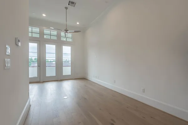 an empty room with a kitchen space and stainless steel appliances