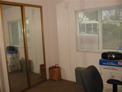 Guest bedroom with mirror closet doors.