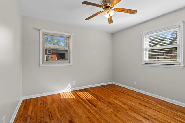 a view of empty room with wooden floor