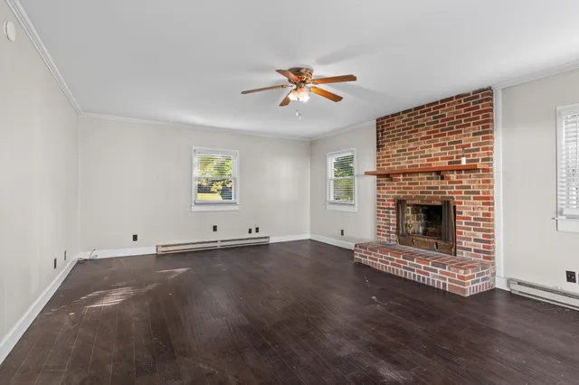 an empty room with windows and fireplace
