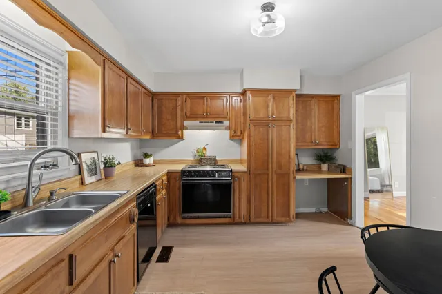 a kitchen with stainless steel appliances granite countertop a refrigerator a sink dishwasher stove top oven and refrigerator