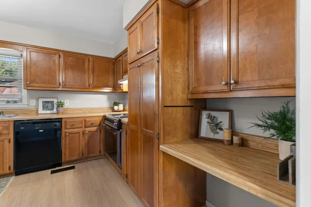 a kitchen with stainless steel appliances granite countertop a refrigerator a stove and a sink