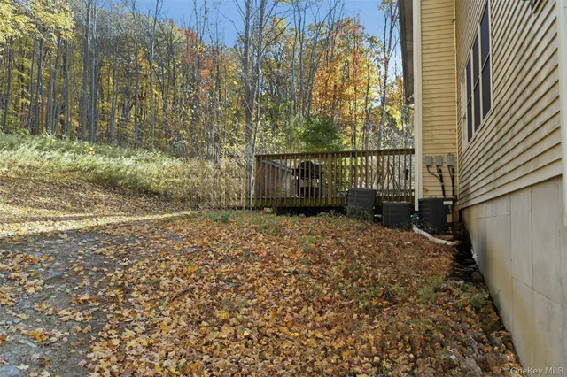 a view of a house with a yard and large trees