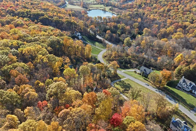 a view of a big house with a big yard and large tree