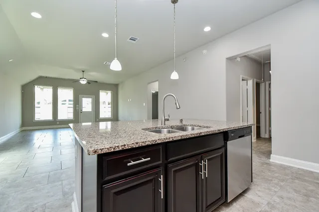 a kitchen with a granite countertop sink and a mirror