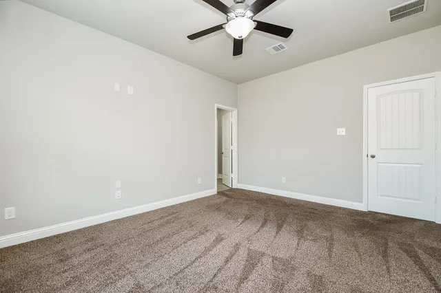 an empty room with a ceiling fan and a window