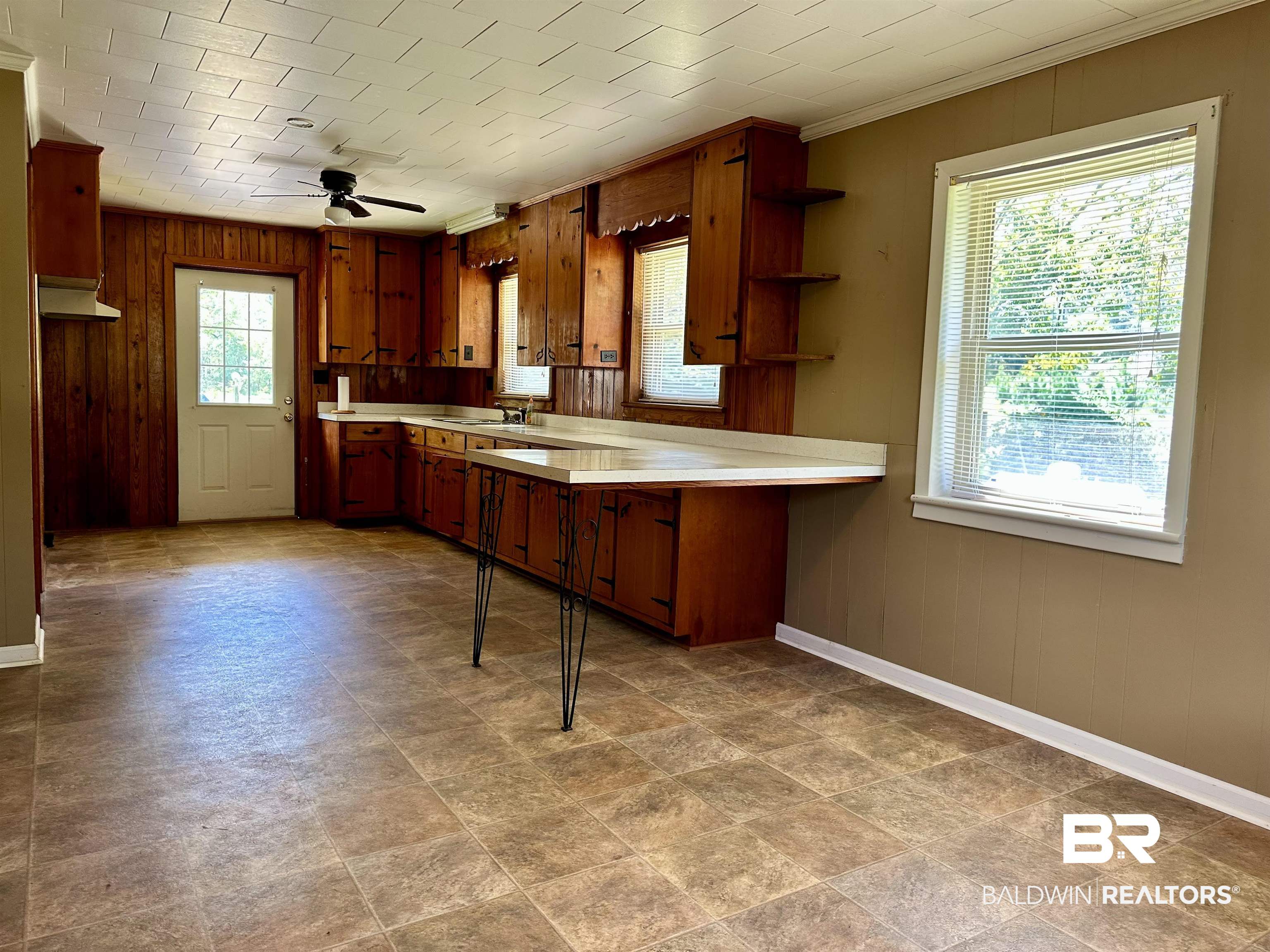 1081 Jay Road Brewton, AL 36426 - Photo 3 of 19 Kitchen featuring ceiling fan, wooden walls, plenty of natural light, and sink