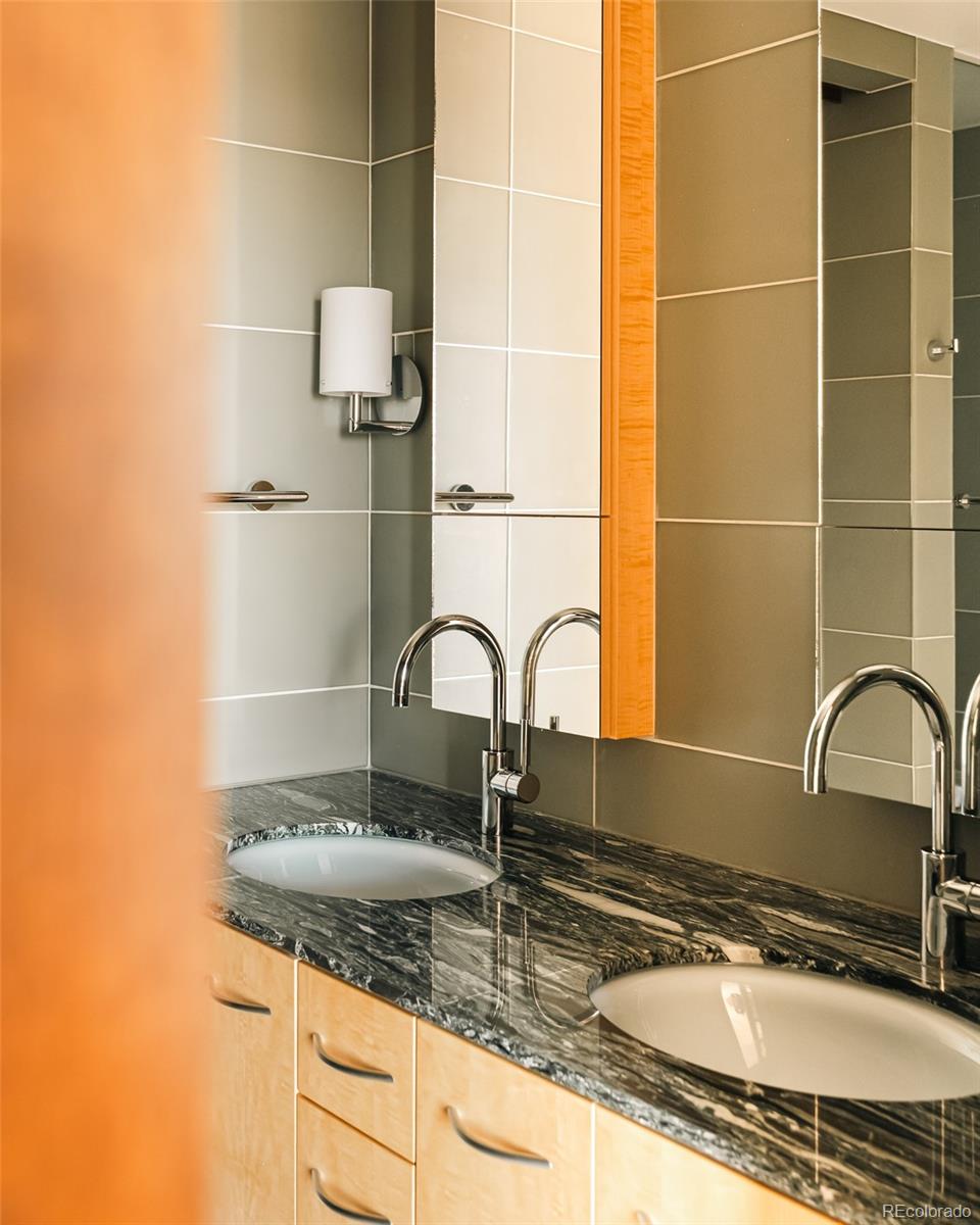 1133 14th Street, Unit 1940 Denver, CO 80202 - Photo 15 of 23 a bathroom with a granite countertop sink a mirror and a shower