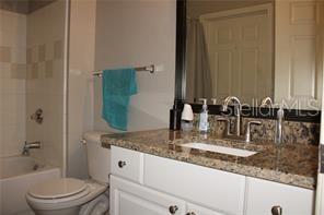 5681 Bidwell Parkway, Unit 204 Sarasota, FL 34233 - Photo 19 of 41 a bathroom with a granite countertop sink and a mirror