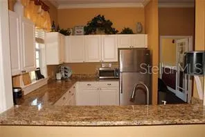 a kitchen with granite countertop white cabinets and sink