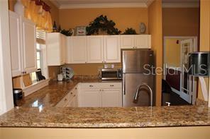 5681 Bidwell Parkway, Unit 204 Sarasota, FL 34233 - Photo 30 of 41 a kitchen with a refrigerator sink and cabinets