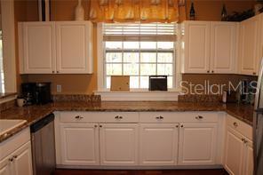 5681 Bidwell Parkway, Unit 204 Sarasota, FL 34233 - Photo 31 of 41 a kitchen with granite countertop white cabinets and sink