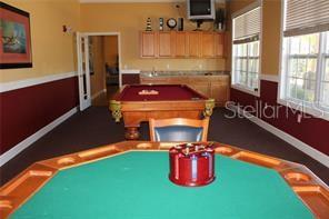5681 Bidwell Parkway, Unit 204 Sarasota, FL 34233 - Photo 32 of 41 a room with pool table windows and a chandelier