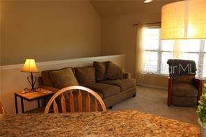 5681 Bidwell Parkway, Unit 204 Sarasota, FL 34233 - Photo 6 of 41 a living room with a couch and a window