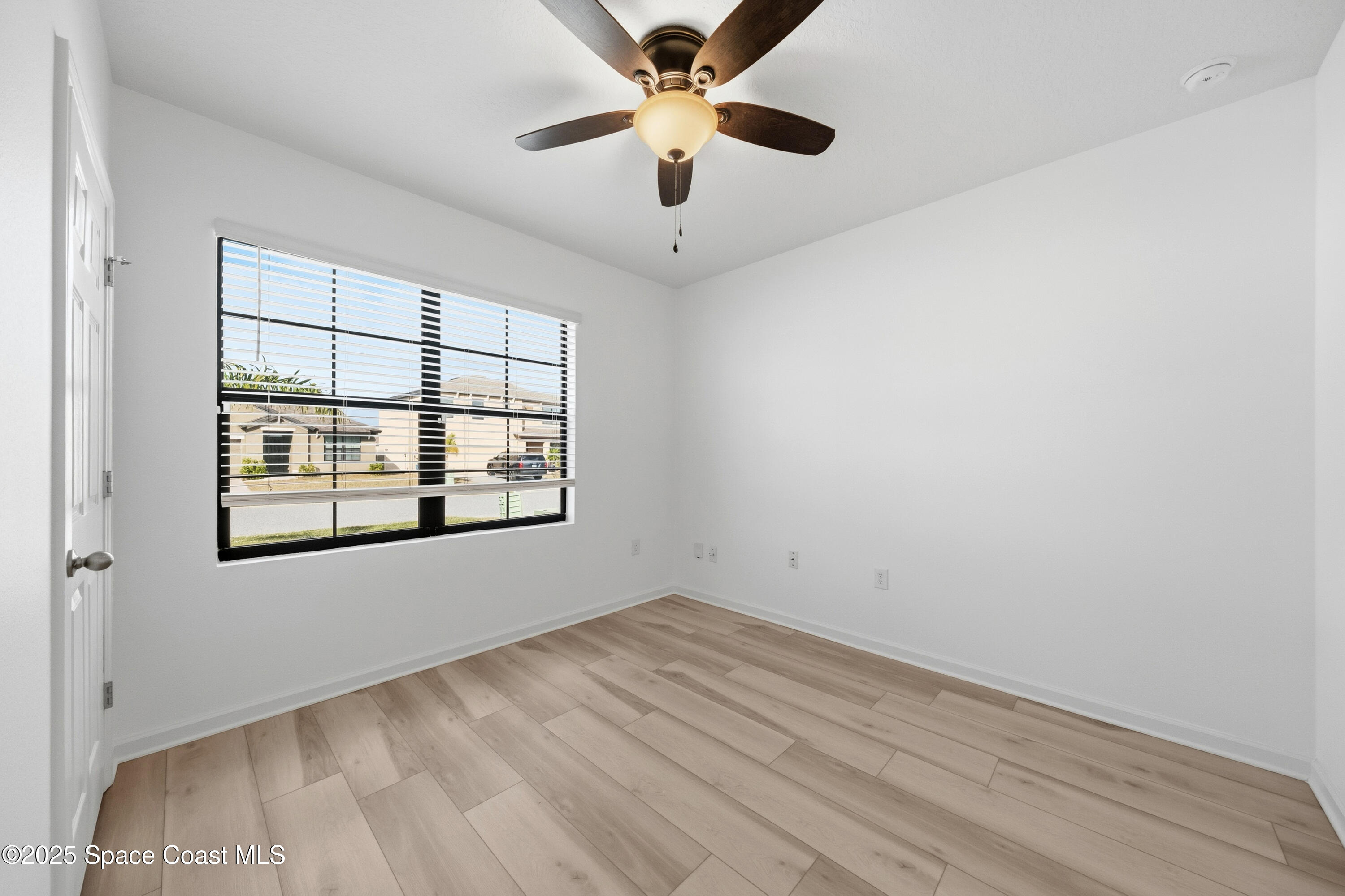 377 Snook Place Cocoa, FL 32927 - Photo 19 of 32 an empty room with a window and a ceiling fan